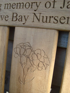 Carnation flower carved into wood on a memorial bench - 4mb2950