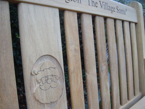 Father Christmas carving into wood on a memorial bench - 4mb2129