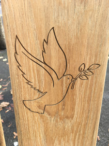 memorial bench with a dove, carrying an olive branch in its beak, carved into the wood - 4mb4578